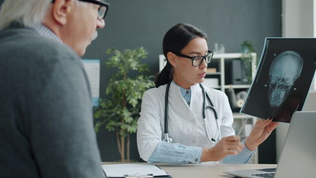 Parent calculating family health insurance premium and deductible costs with a calculator