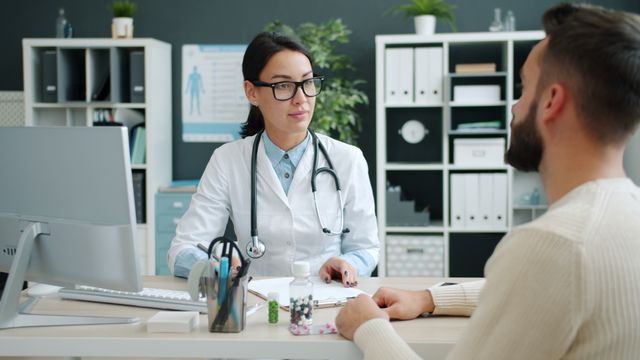 Household budgeting for monthly health insurance premiums and medical costs using a laptop and financial documents