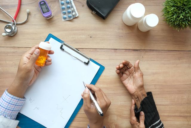 Person calculating out-of-pocket healthcare costs and insurance deductibles with a calculator and paperwork